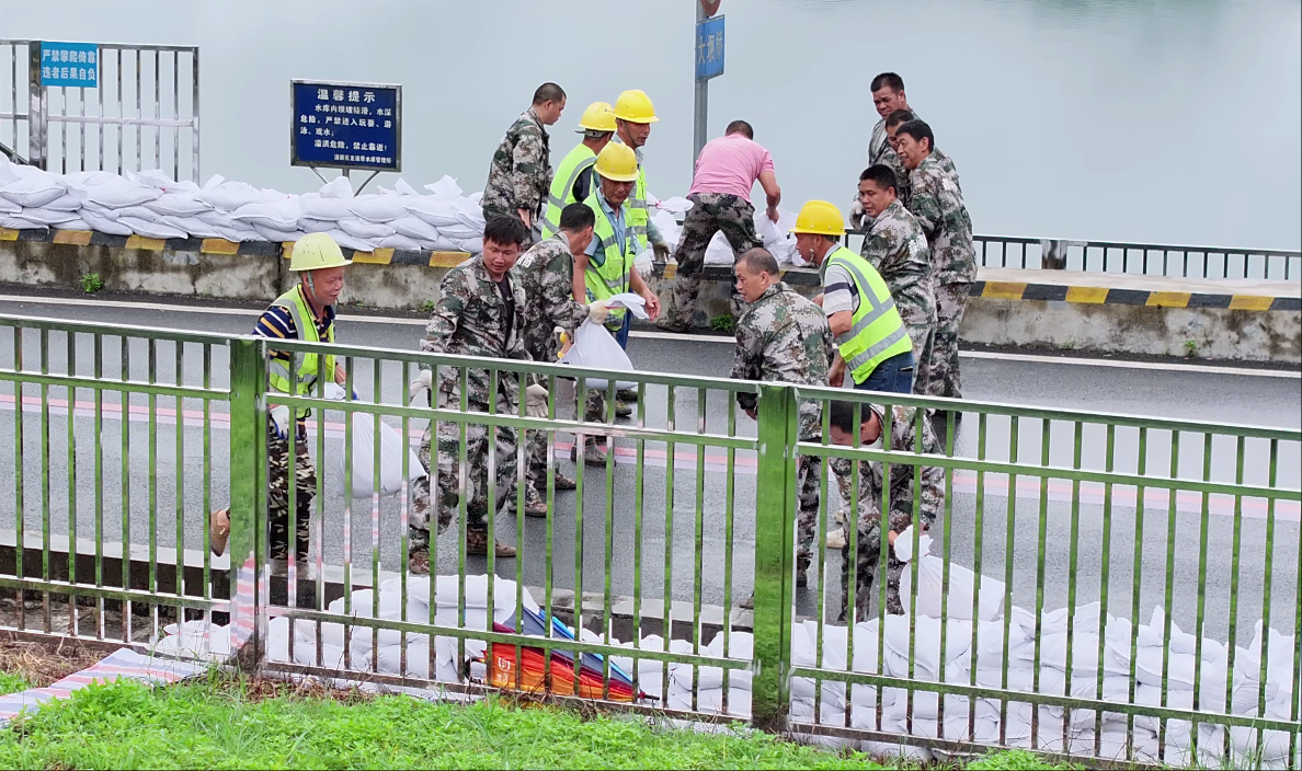 上图为抢险队伍在防浪墙上堆筑子堤.png